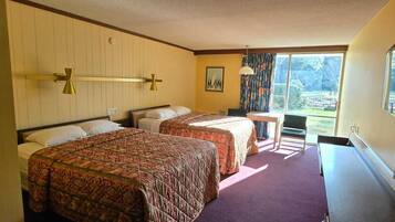 Une chambre d’hôtel avec deux lits, un bureau, une chaise, une télévision et une grande fenêtre.