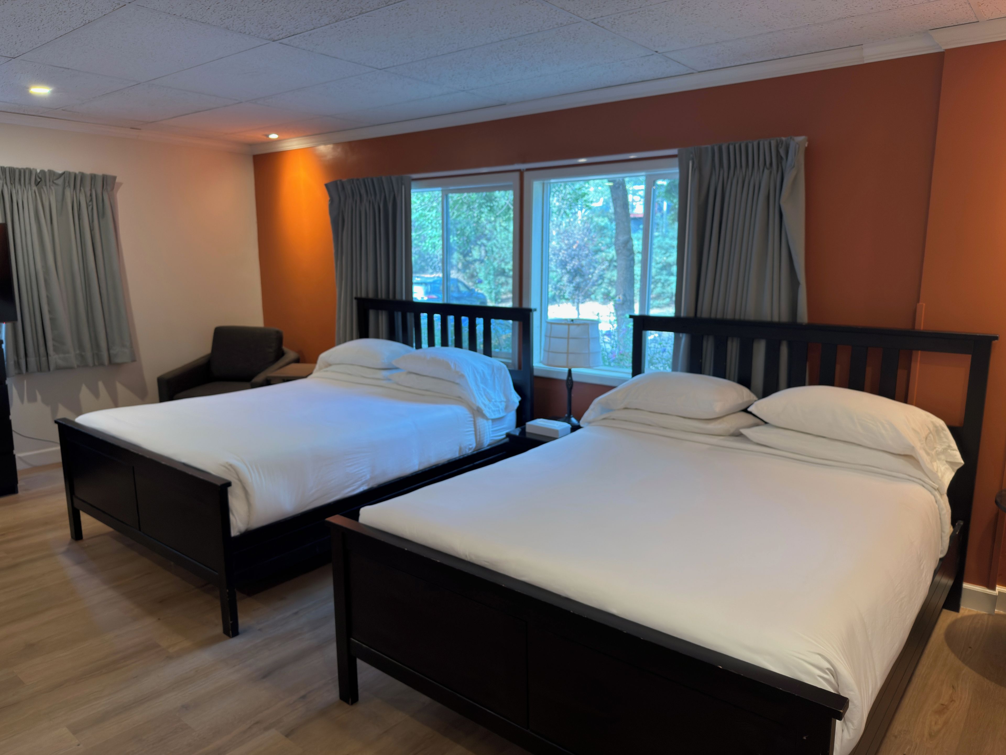 Una habitación de hotel con dos camas, un escritorio y una silla.