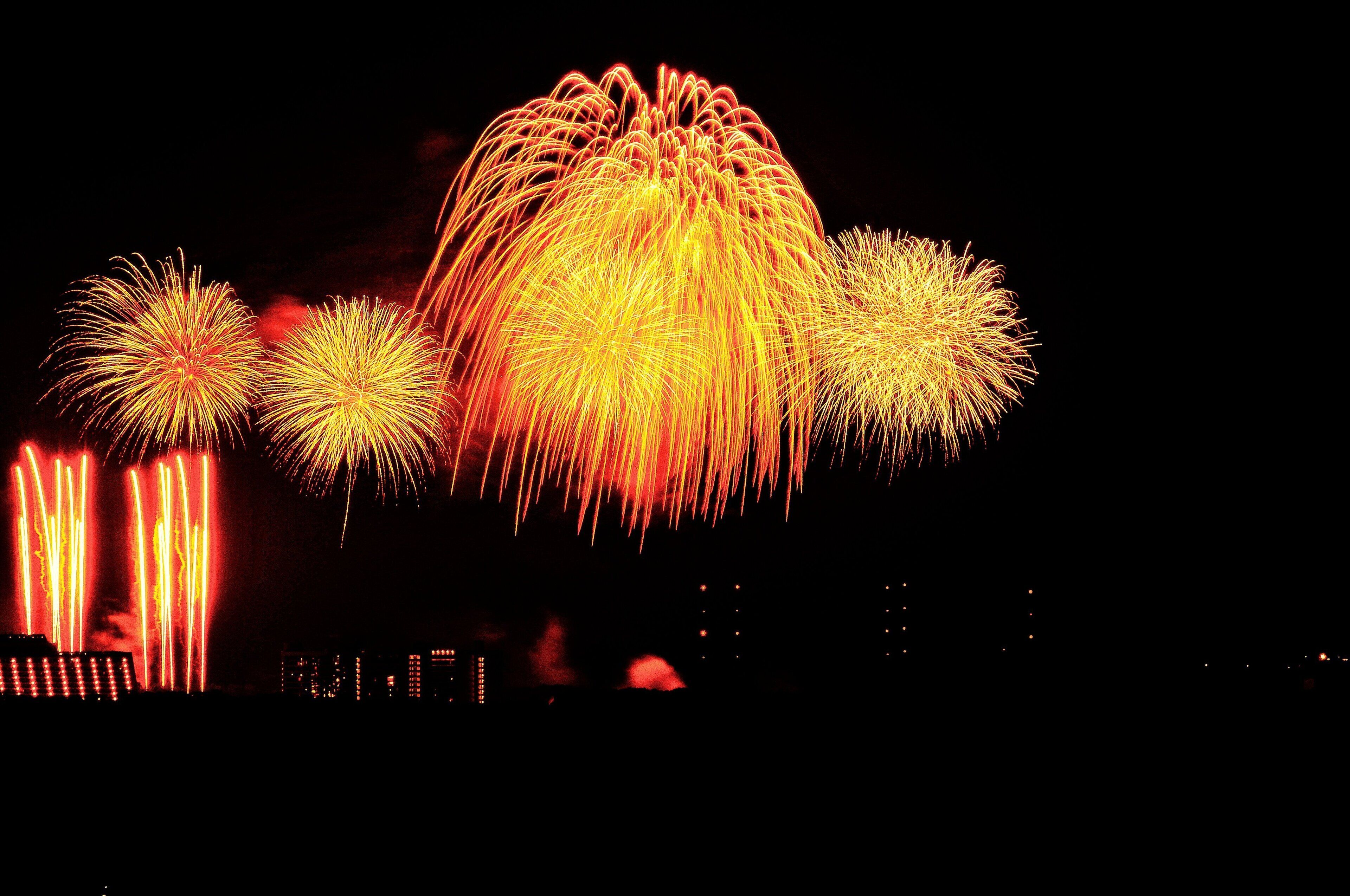 A night scene with multiple fireworks displays.