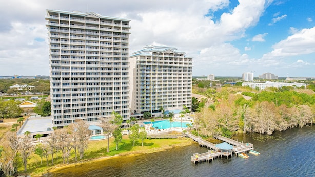 A high-rise hotel with a swimming pool and dock. - Blue Heron Beach Resort (Orlando)