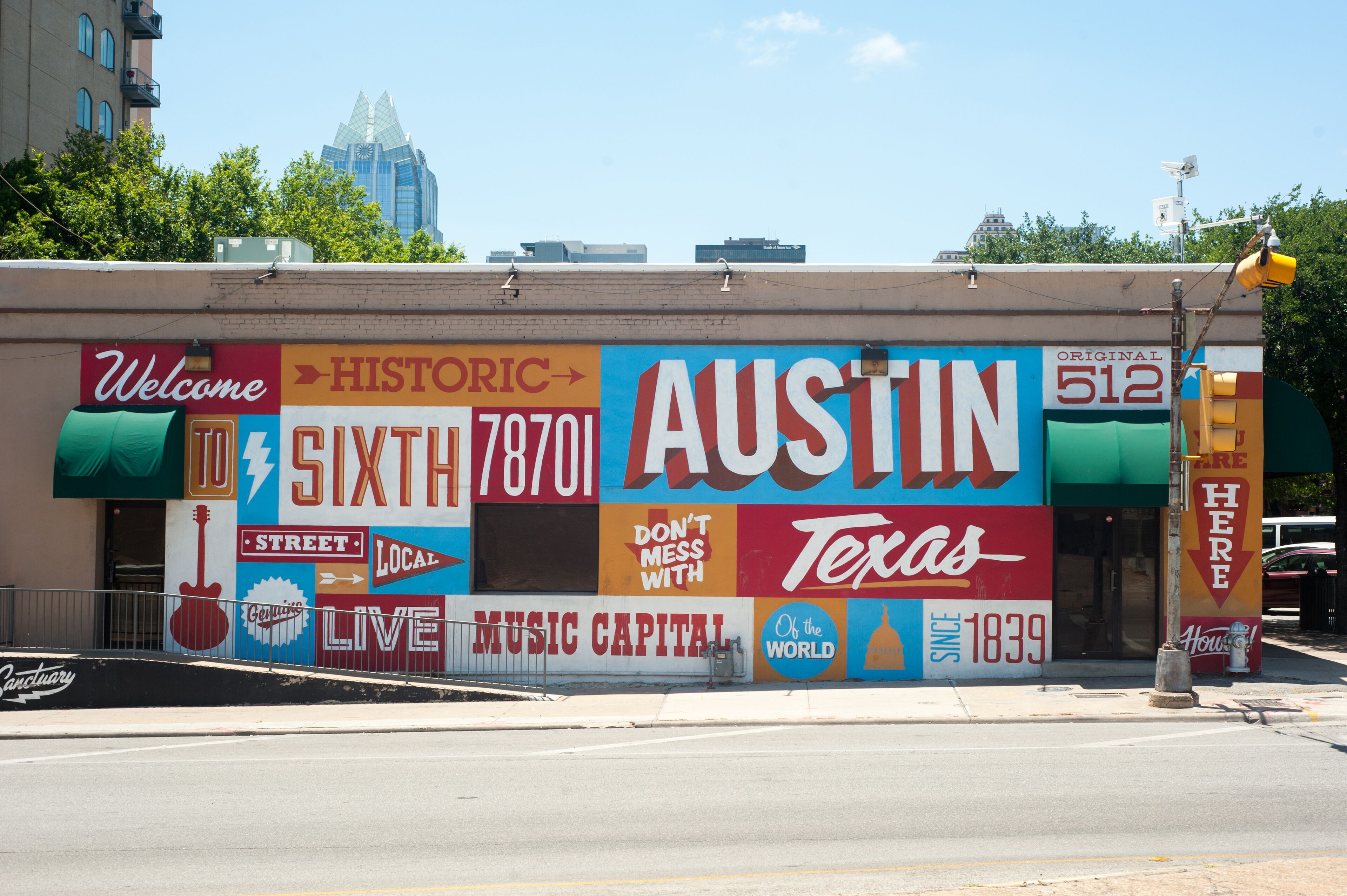 Een gebouw met een kleurrijke muurschildering waarop de woorden 'Austin Texas' en 'Muziekhoofdstad' staan.