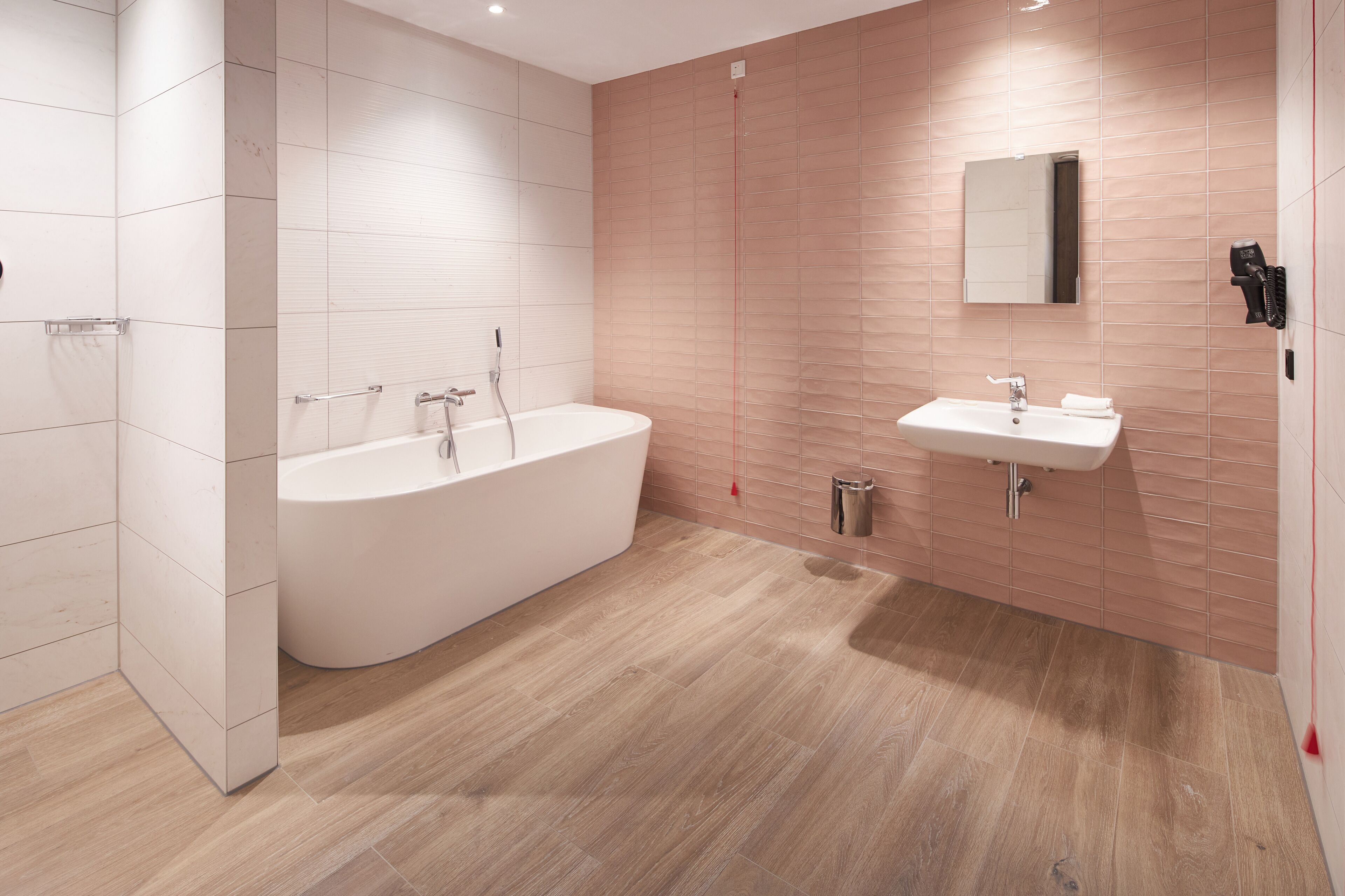 A modern bathroom with a freestanding bathtub, a sink, and a mirror.
