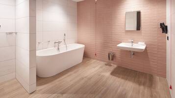 A modern bathroom with a freestanding bathtub, a sink, and a mirror.