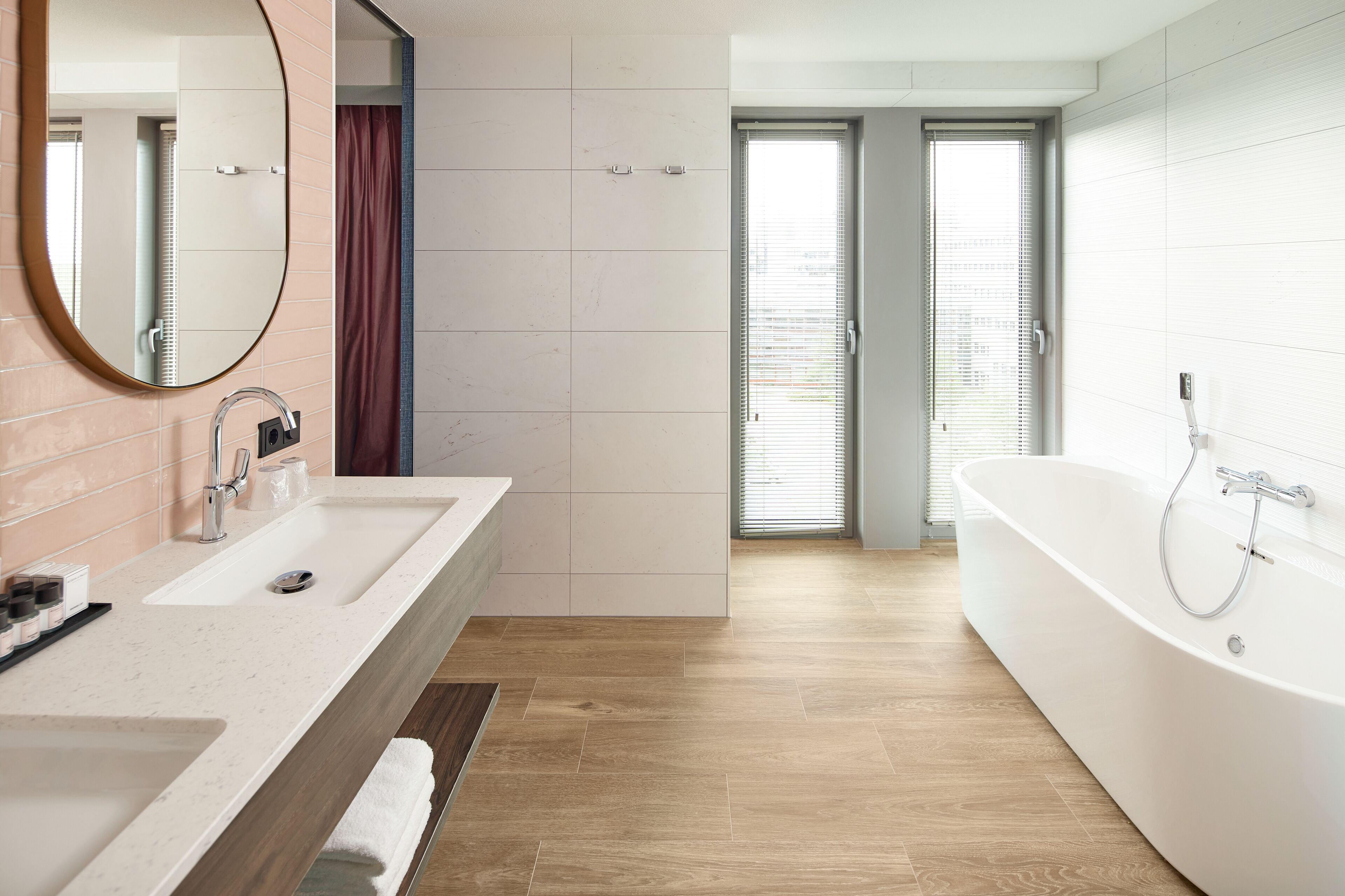Ein modernes Badezimmer mit einer großen Badewanne, einem Doppelwaschbecken und einem Spiegel.
