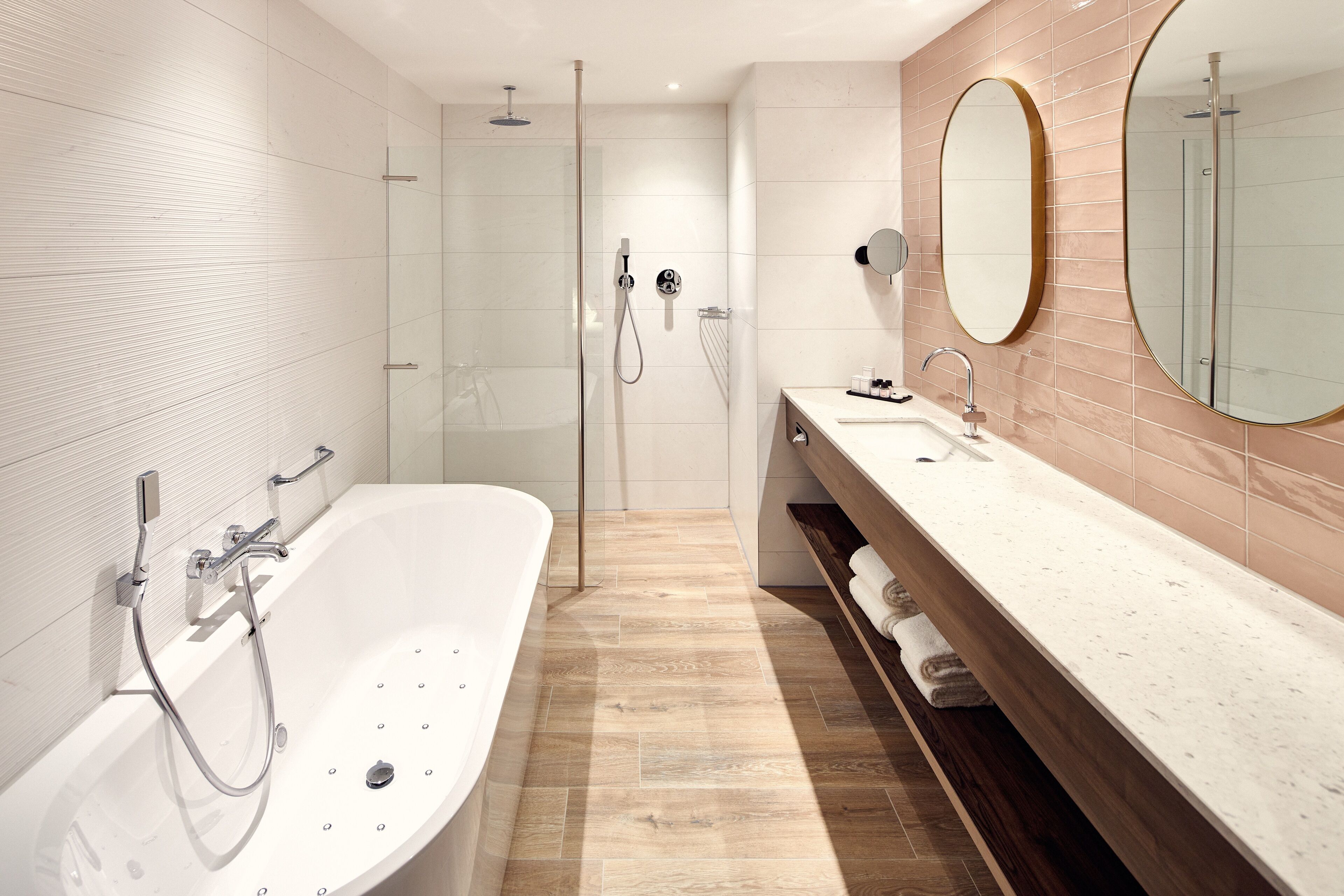 Une salle de bain moderne avec une baignoire sur pieds, une douche à parois de verre et un meuble-lavabo avec un miroir.
