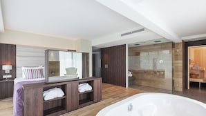 A modern bathroom with a large bathtub, a vanity with a mirror, and a shower area. - Van der Valk Hotel Haarlem (Haarlem)