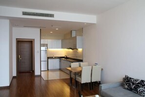 Una cocina moderna con zona de comedor, sofá y puerta que da a otra habitación.