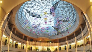 A multi-level atrium with a glass dome ceiling, multiple floors, and a central staircase. - Hongyi Hotel Wuhan University (Wuhan)