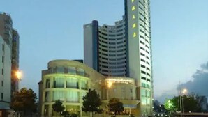 A modern hotel with a curved facade and a tall, rectangular tower. - Hongyi Hotel Wuhan University (Wuhan)