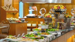Un buffet proposant une variété de plats, notamment des fruits, des salades et des boissons.