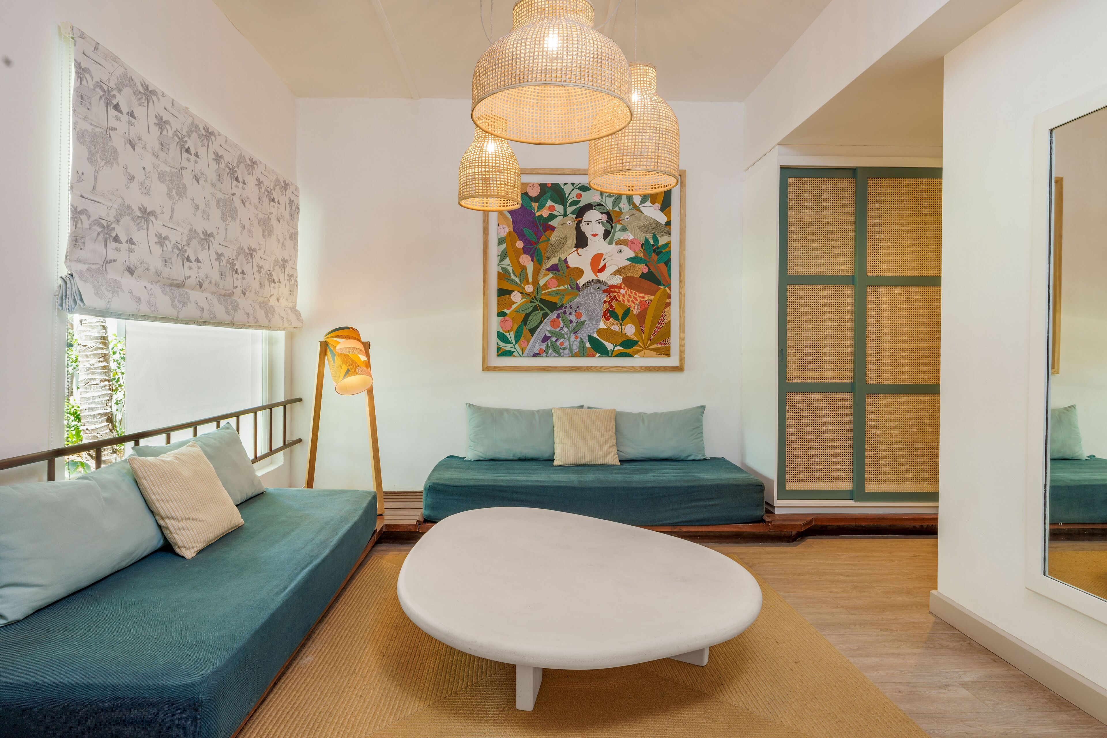 A modern living room with a sofa, a coffee table, and a painting on the wall.