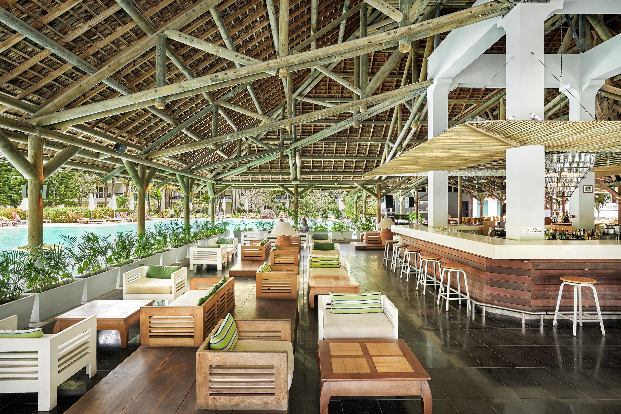 An indoor pool area with wooden furniture and a bar.
