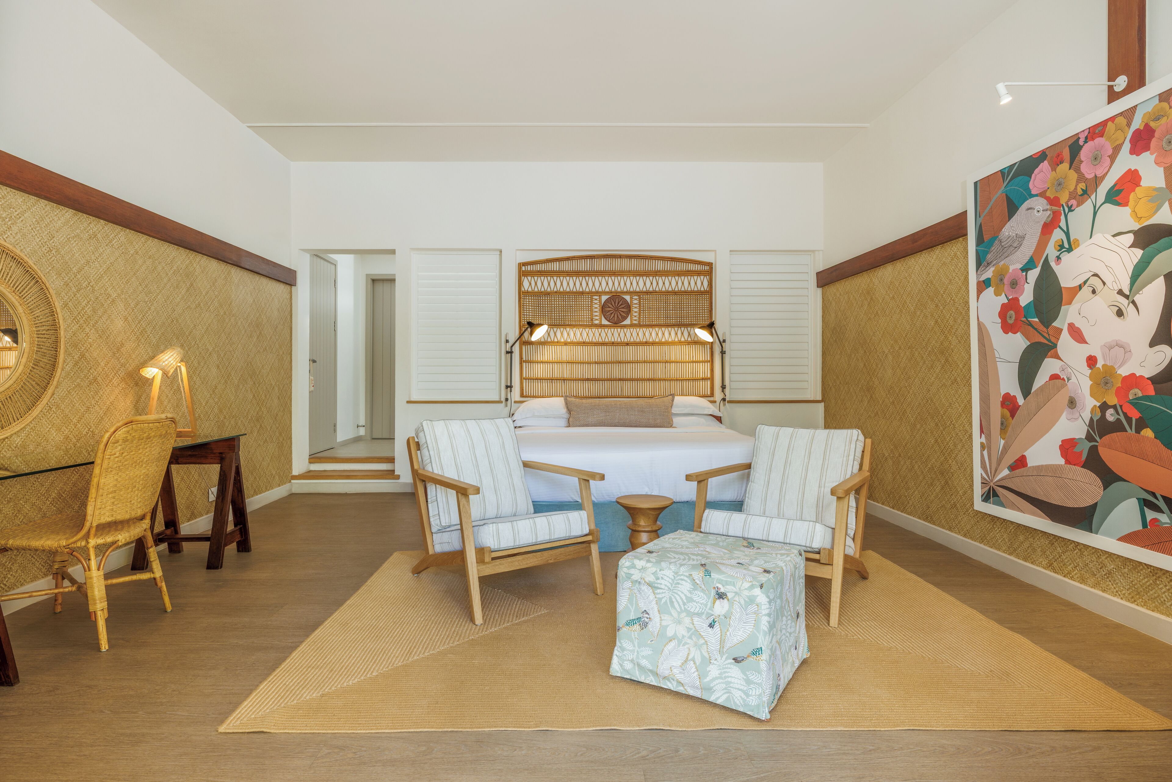 Ruime slaapkamer met een groot bed, twee nachtkastjes, een stoel en een klein tafeltje.