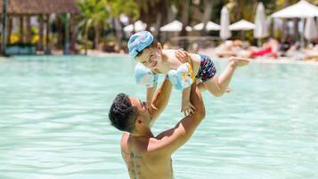 Una piscina al aire libre, sombrillas, sillones reclinables de piscina