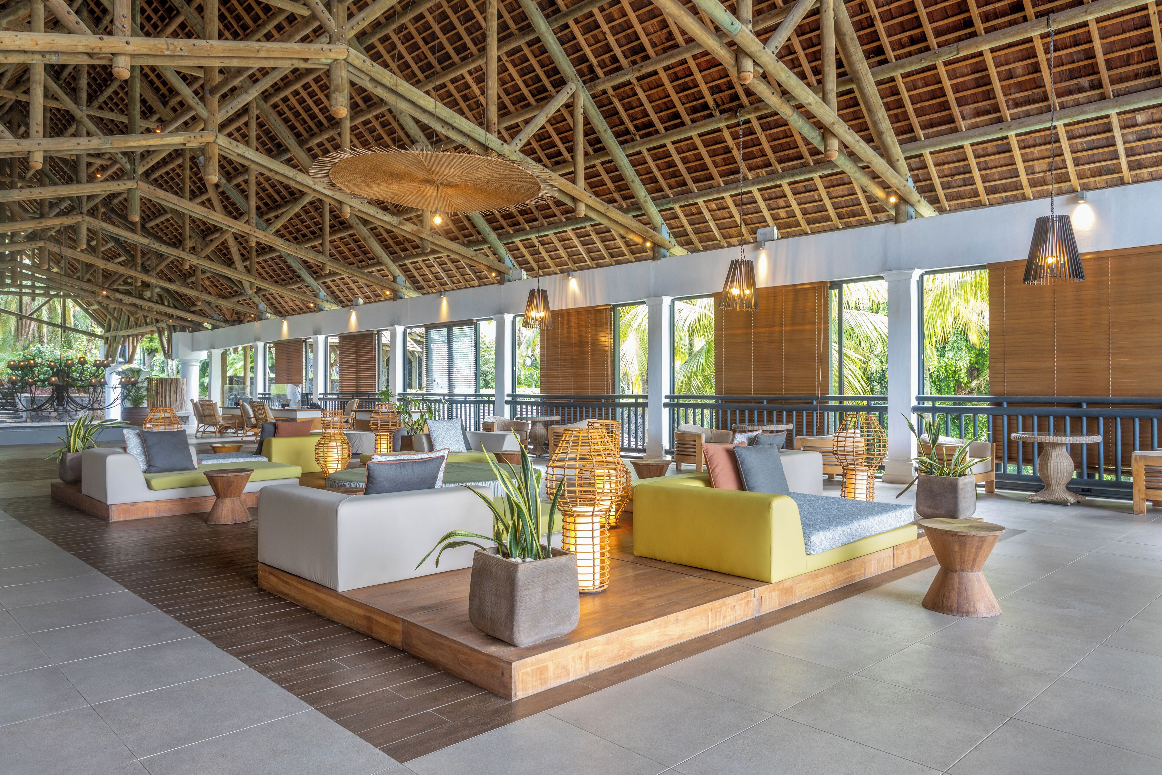Amplia sala de estar con diversas opciones de asiento, incluyendo sofás y sillones, dispuestas alrededor de una plataforma de madera central.