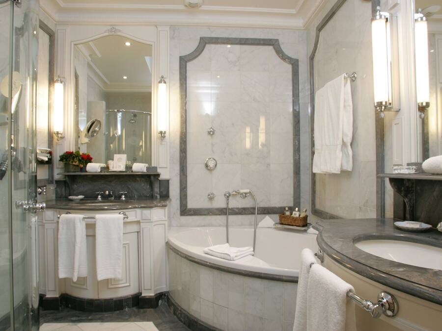 Un baño lujoso con una bañera grande, una zona de ducha separada y un tocador con lavabo.