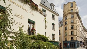 A building with the sign 'Luxembourg Paris' and balconies with plants.
