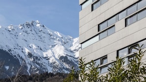 Un edificio moderno con uno sfondo montuoso.