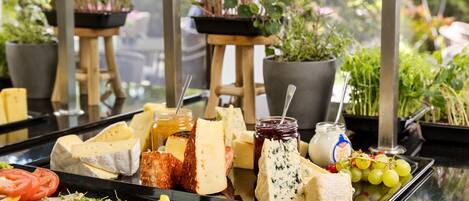 A cheese and meat platter with various cheeses, meats, and fruits on a tray.