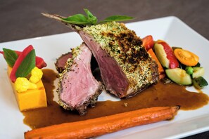 Un plat composé d’une pièce de viande principale, de légumes et d’une sauce.