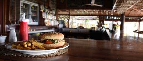 A restaurant interior with a table set for a meal, including a burger and fries.