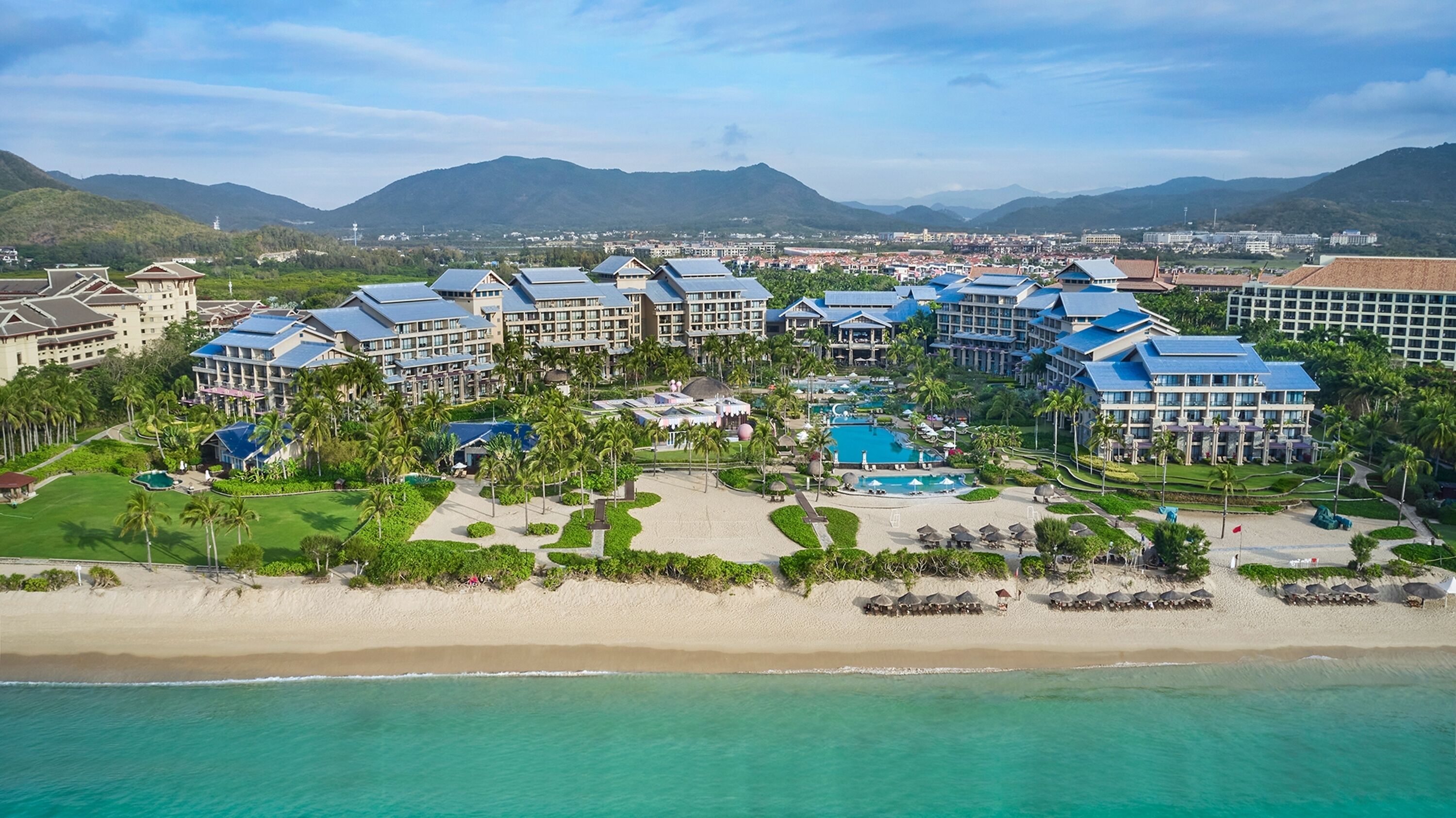 Un resort con varias edificaciones, una piscina central y acceso directo a la playa.
