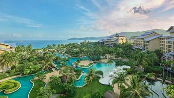 A resort with multiple swimming pools, lush greenery, and beachfront views.