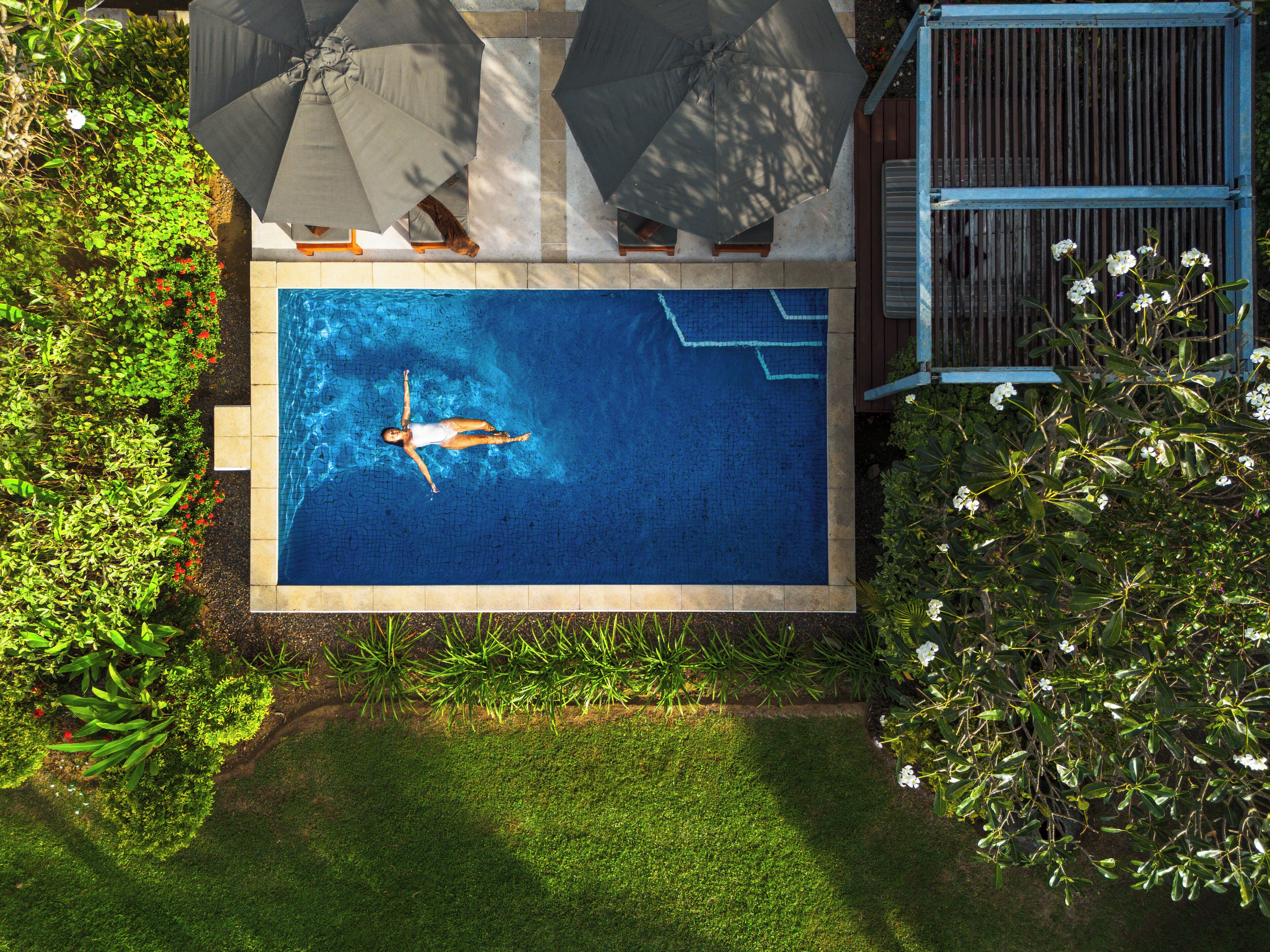 A rectangular swimming pool with a person floating in the center.