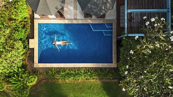 A rectangular swimming pool with a person floating in the center.