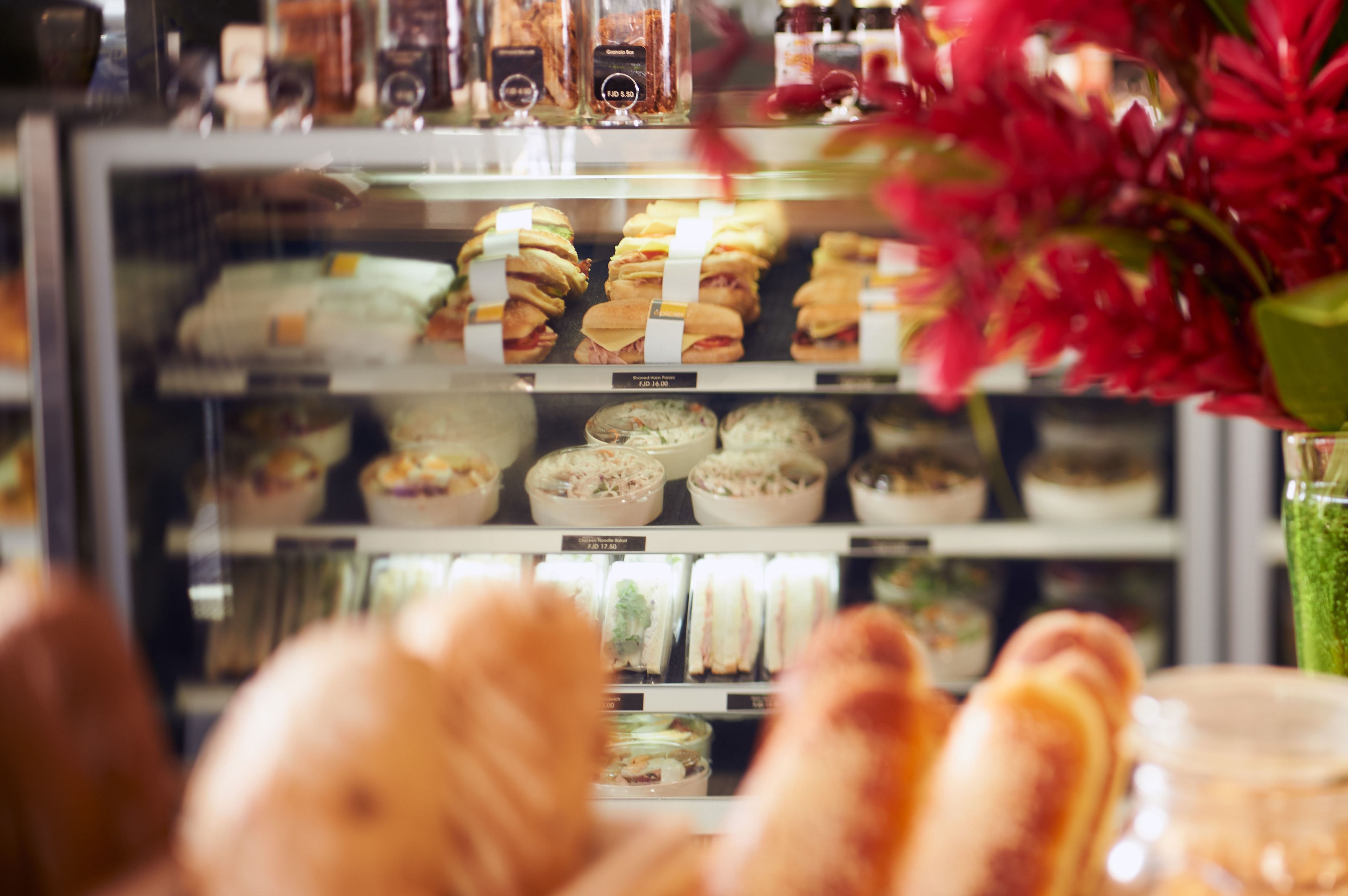 A bakery display case with various baked goods and a glass of iced tea.