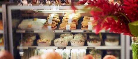 A bakery display case with various baked goods and a glass of iced tea.