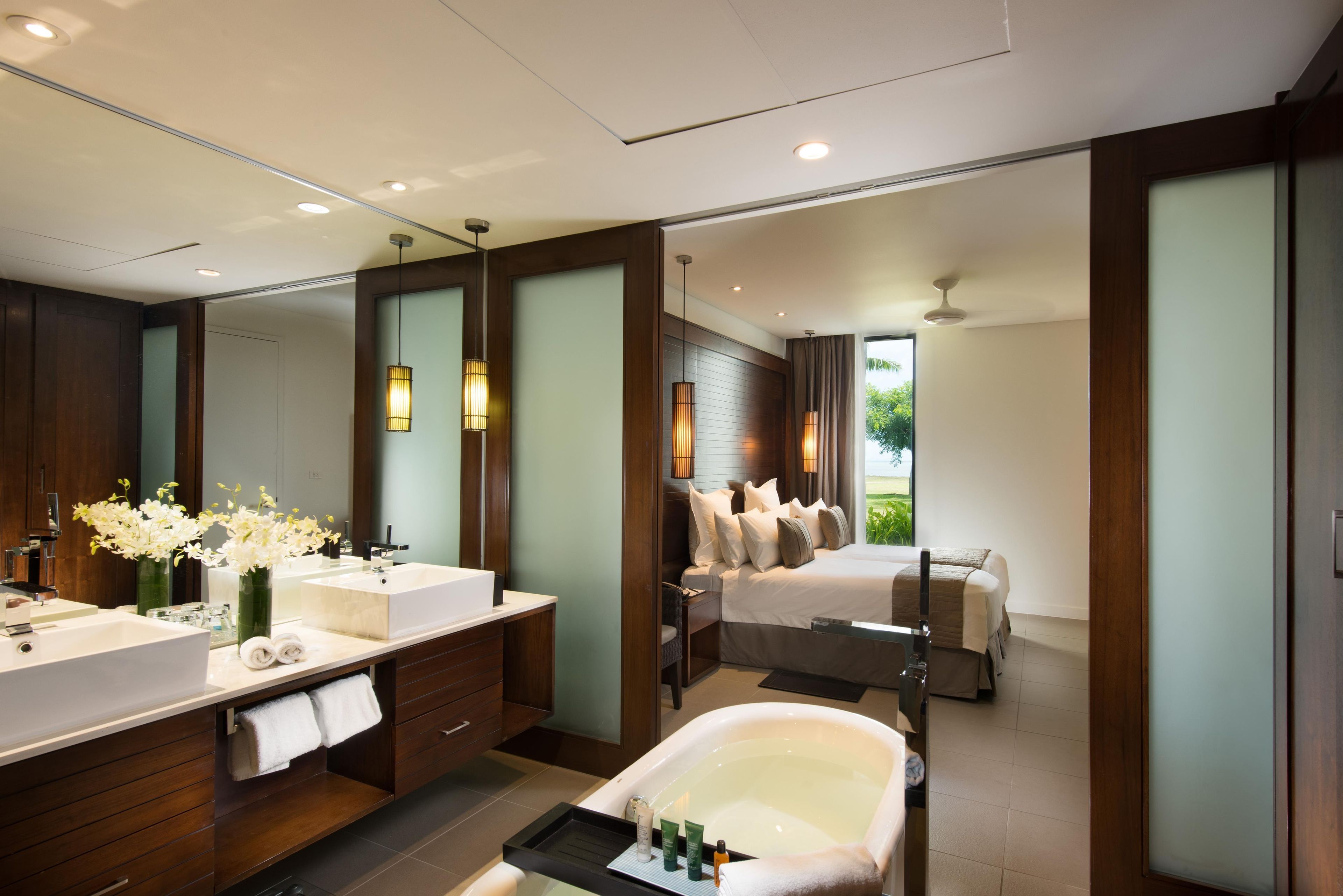 A modern bathroom with a large mirror, a bathtub, and a separate shower area.