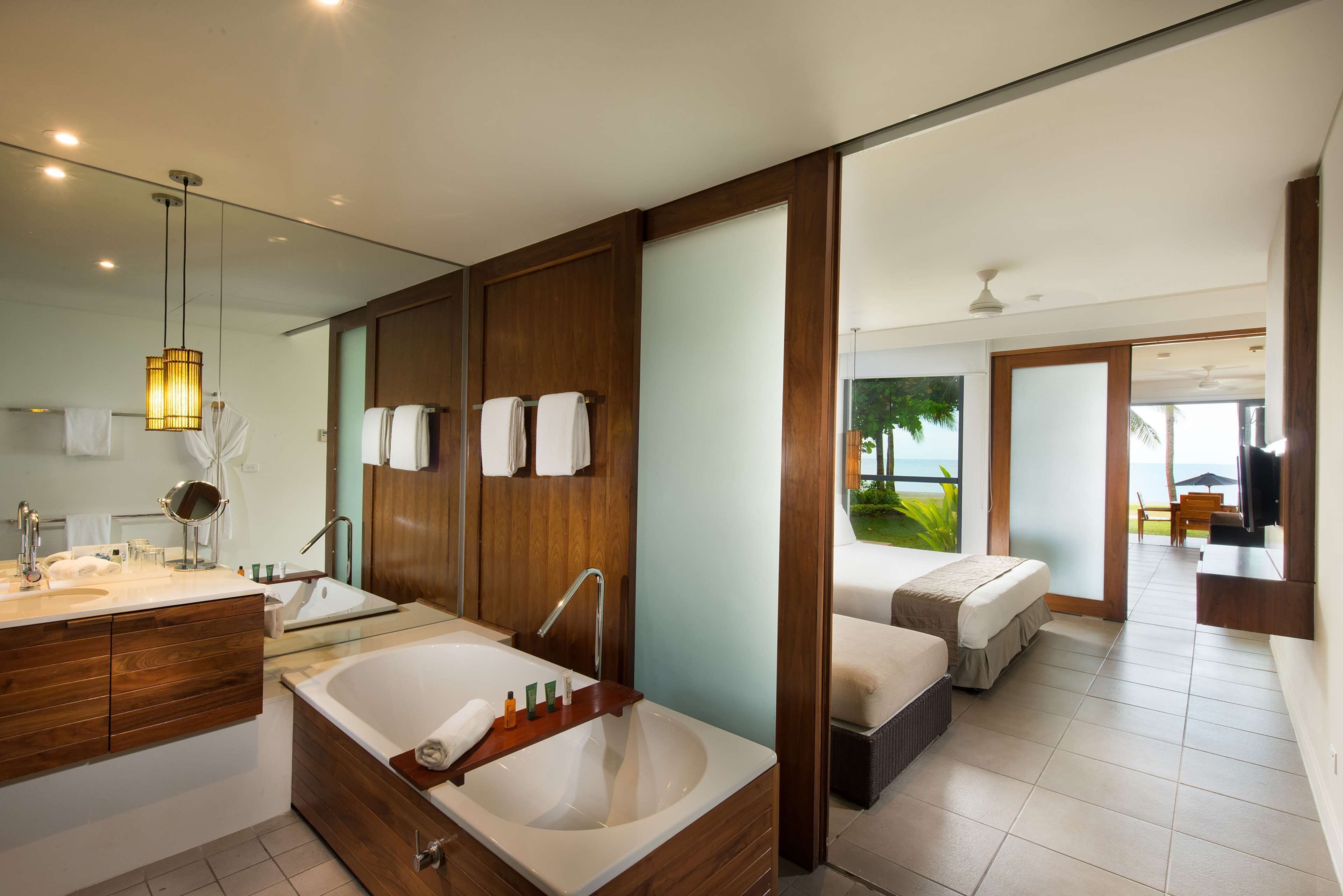 Une salle de bain moderne dotée d’une grande baignoire, d’un meuble-lavabo avec miroir et d’un espace douche.
