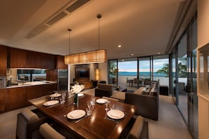 A modern kitchen with a dining area, large windows, and a view of the ocean. - Hilton Fiji Beach Resort and Spa (Nadi)