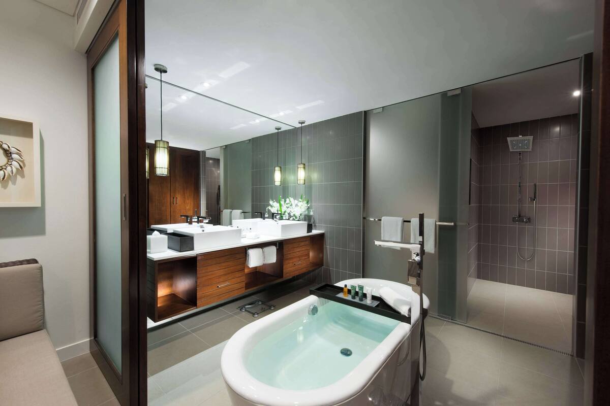 Ein modernes Badezimmer mit einer freistehenden Badewanne, einem großen Spiegel und einer Duschkabine.