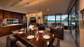 A modern kitchen with a dining area, large windows, and a view of the ocean. - Hilton Fiji Beach Resort and Spa (Nadi)