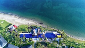 An aerial view of a resort with a large pool, beach access, and palm trees. - Hilton Fiji Beach Resort and Spa (Nadi)