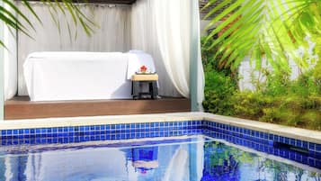 Relax by the serene pool surrounded by lush greenery and a tranquil atmosphere.