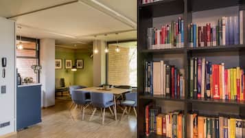 Eine moderne Küche mit Essbereich, Holzboden und einer Bücherwand.