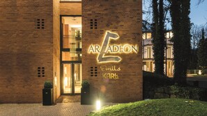 A building with a prominent illuminated sign reading 'ARADEN Emil Karl' and a glass entrance. - Arcadeon (Hagen)