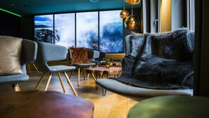A modern interior with a view of a waterfall, contemporary furniture, and ambient lighting. - Arcadeon (Hagen)