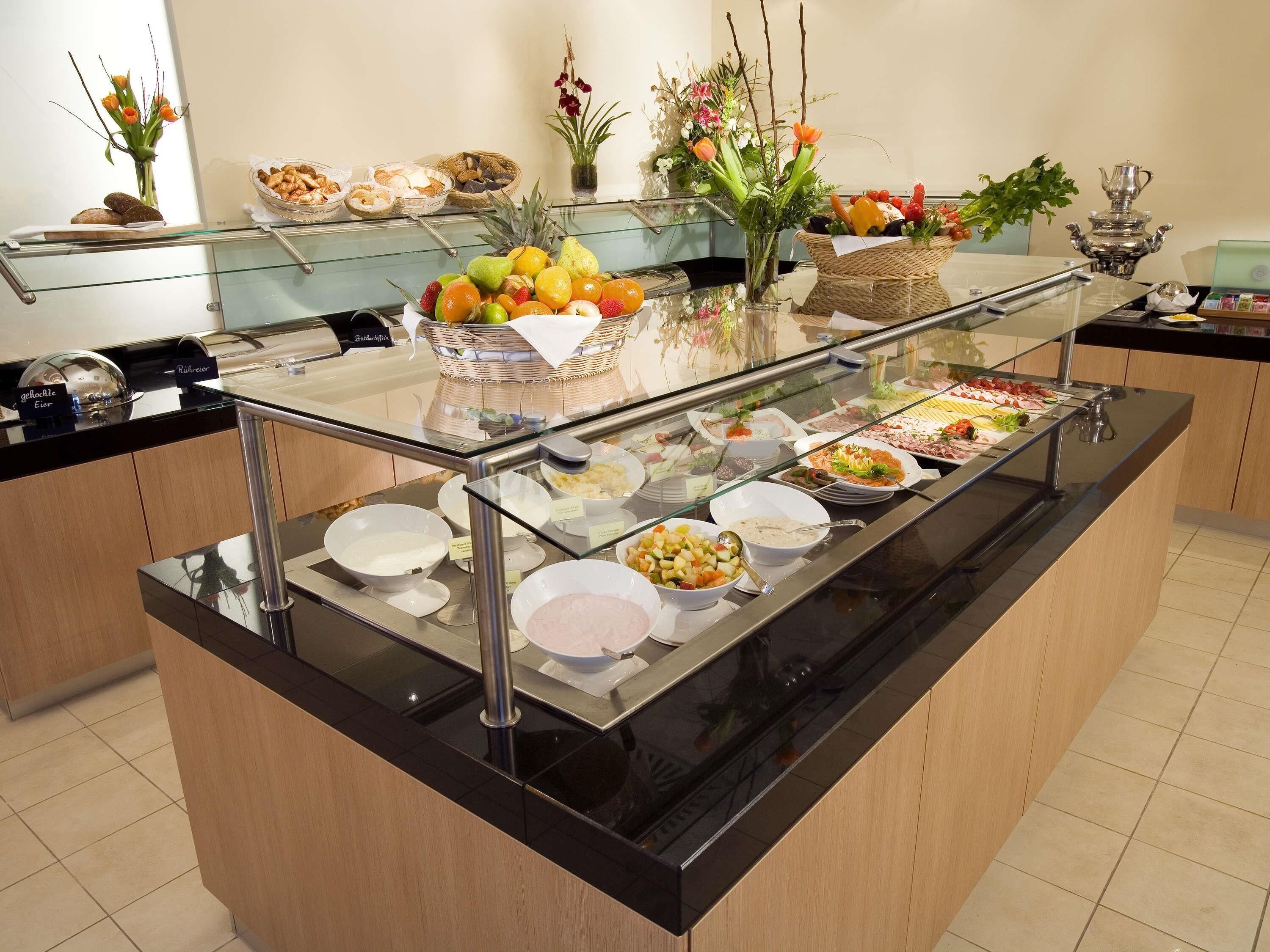 Buffet com diversos alimentos e uma vitrine de vidro.