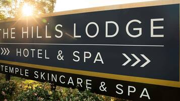 En skylt för The Hills Lodge, som visar att det är ett hotell och spa med ett Temple Skincare & Spa.