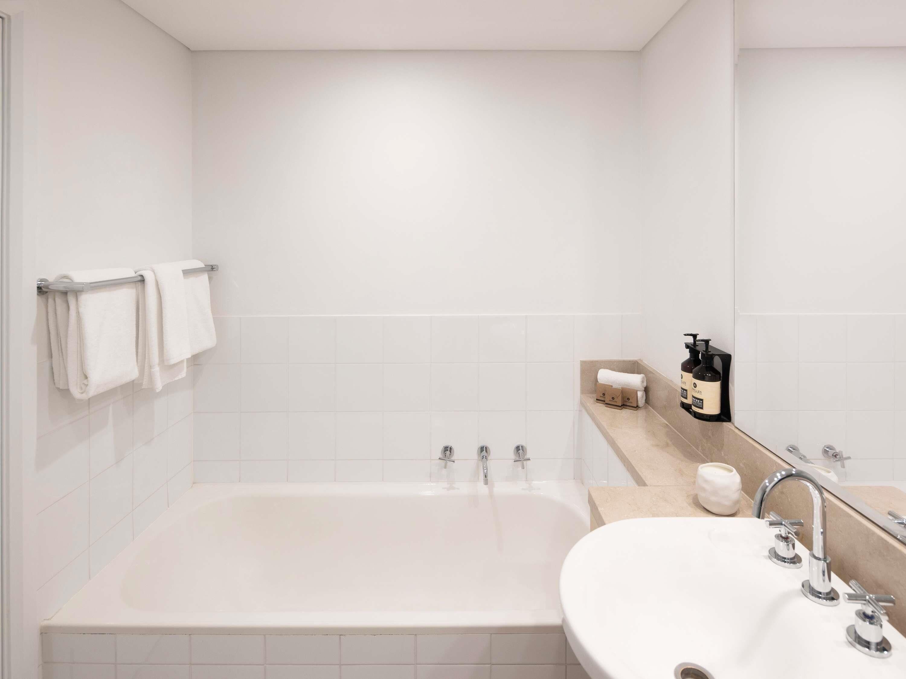 Un baño moderno con bañera, lavabo y espejo.