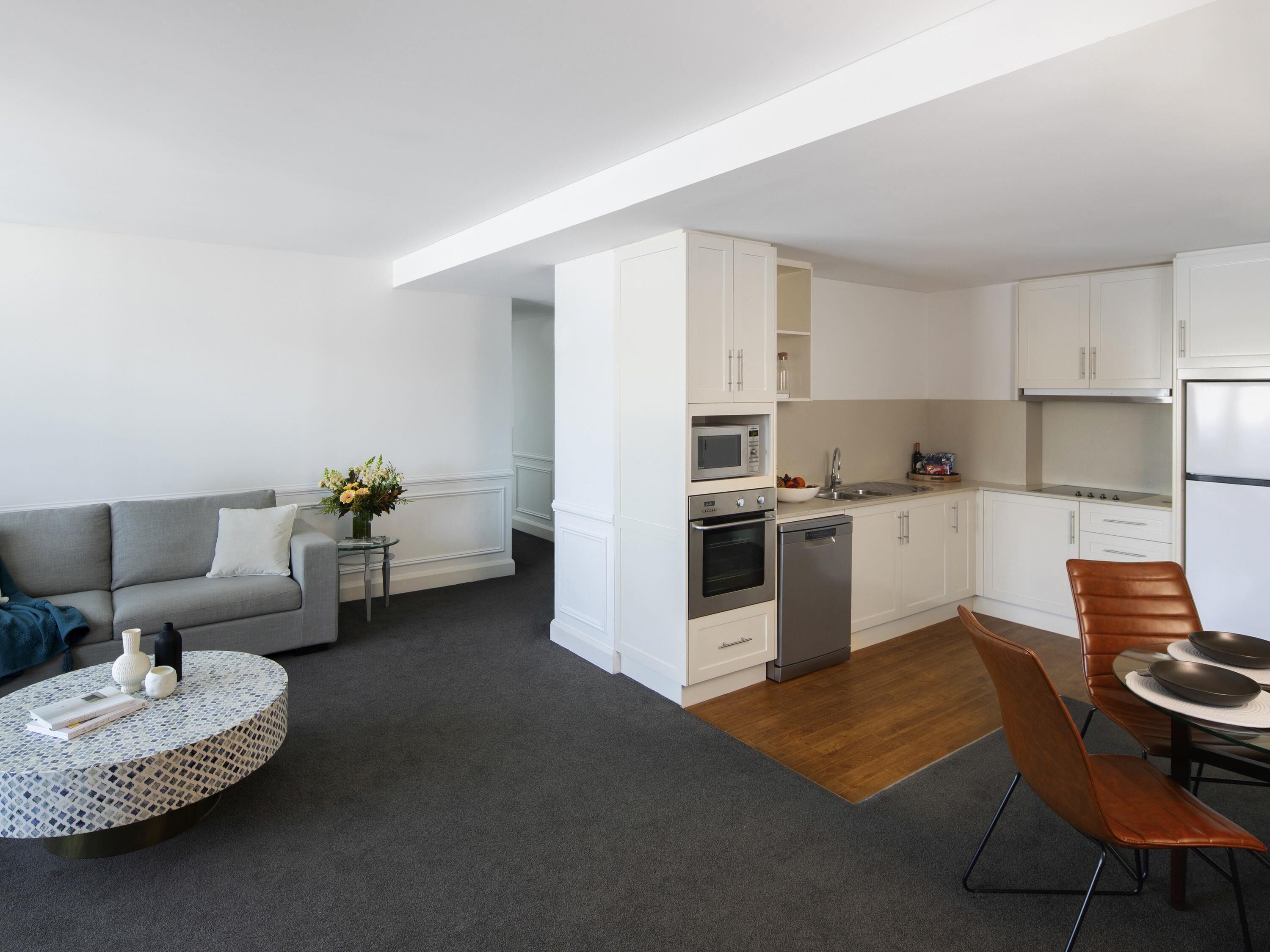 A modern apartment with a living area, kitchen, and dining space.