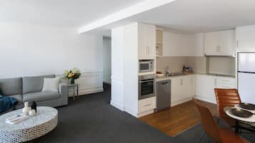 A modern apartment with a living area, kitchen, and dining space.