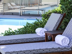A poolside lounge area with patterned cushions and a wooden table. - Peppers The Hills Lodge (Castle Hill)