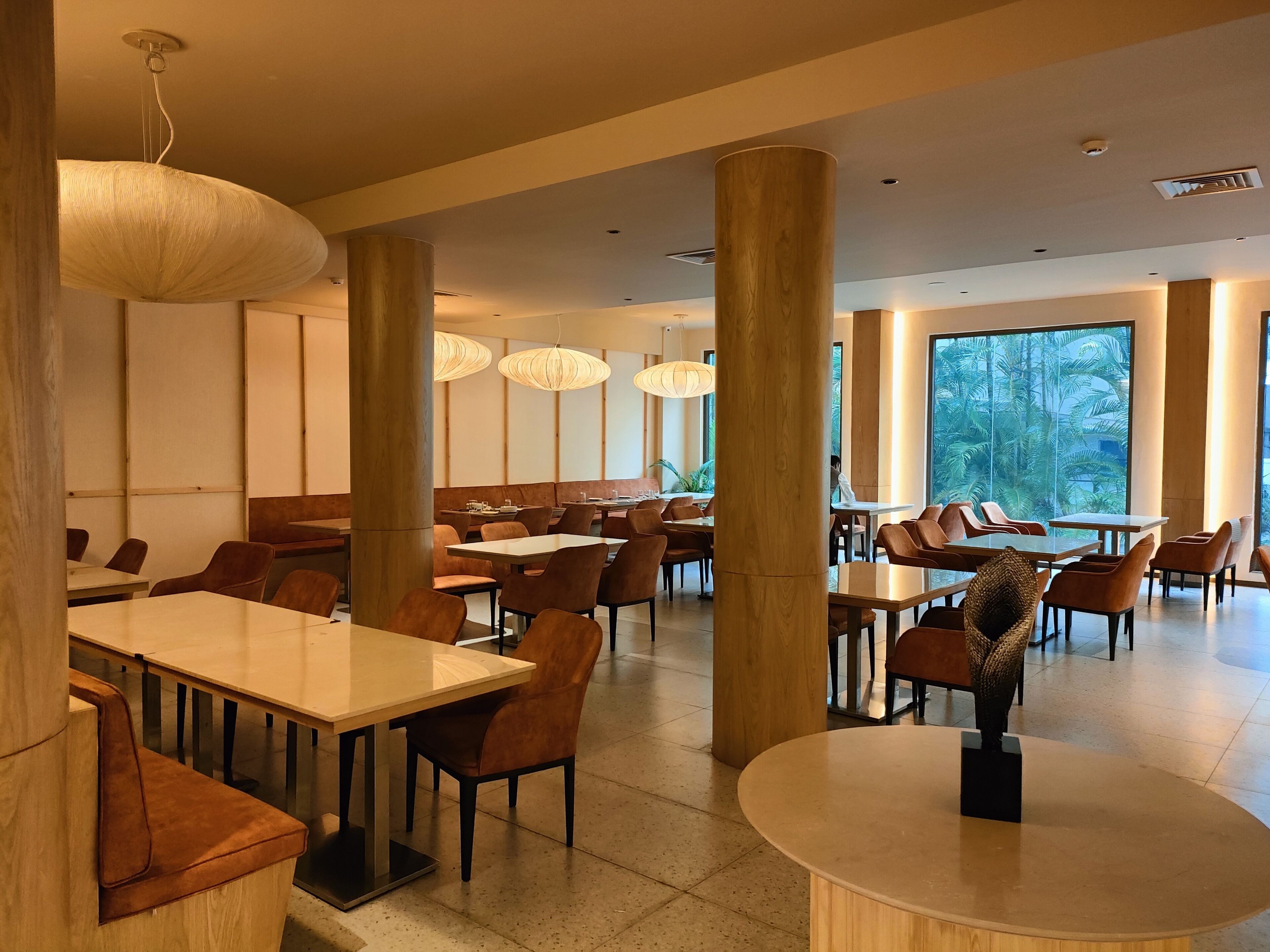 Un comedor amplio con techos altos, ventanas grandes y muebles modernos.