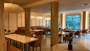 Un comedor amplio con techos altos, ventanas grandes y muebles modernos.