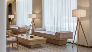 A modern hotel room with a sofa, two floor lamps, a coffee table, and a large window with sheer curtains. - 37th Crescent Hotel (Bengaluru)